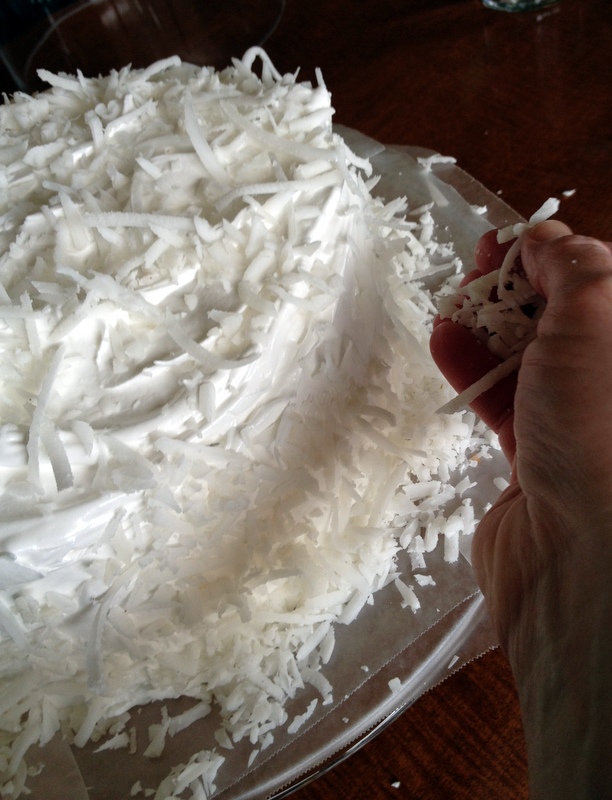 Freshly grated, @@#!% %%^#$ coconut is pressed into the frosting.